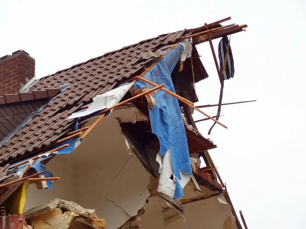 Zniszczona dachówka z widocznymi pęknięciami i mchem, sygnalizująca konieczność renowacji pokrycia dachowego.